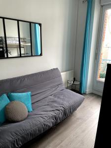 a gray couch in a living room with a mirror at Appartement Rue de la gare centre ville in Quiberon