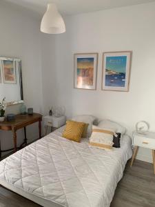 a bedroom with a white bed with two pillows on it at Appartement Rue de la gare centre ville in Quiberon
