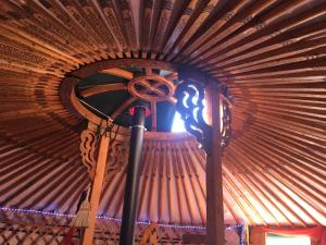 a room with a wooden ceiling with a fan at Les songes du chêne in Augirein