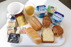 a plate of food with bread and other breakfast foods at Premiere Classe Nice - Promenade des Anglais in Nice