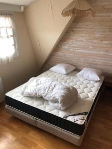 Una cama con dos almohadas encima en una habitación. en Maison Place manemeur, en Quiberon