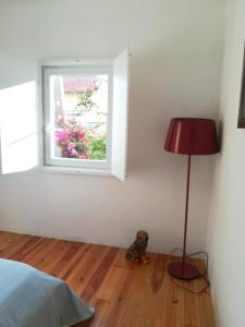 a bedroom with a bed and a lamp and a window at Casa do Cristo Rei in Almada