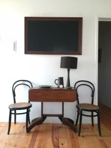 a desk with two chairs and a lamp on it at Casa do Cristo Rei in Almada