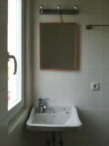 a bathroom with a white sink and a mirror at Casa do Cristo Rei in Almada