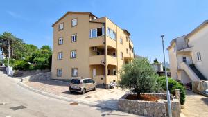 un edificio con un'auto parcheggiata di fronte di Apartment Goran a Krk
