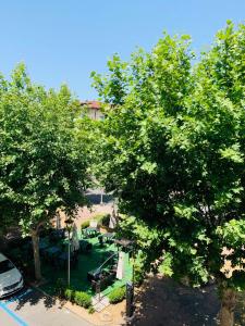 widok na park z drzewami i stołami w obiekcie I Platani 3 w Montecatini Terme
