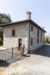 un edificio de piedra con una valla delante en Casa Rural Camangu, en Camango