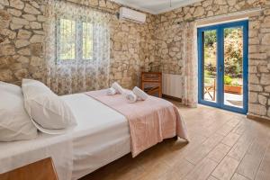 a bedroom with a bed with towels on it at Stone House in olive Grove - former Denis Stone Villa in Trapezaki