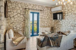 a living room with a stone wall at Stone House in olive Grove - former Denis Stone Villa in Trapezaki