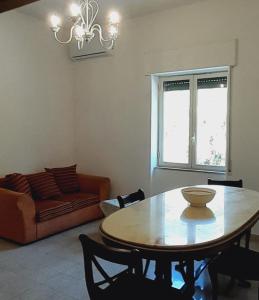 sala de estar con mesa y sofá en Sindaro house en Messina