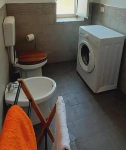 a bathroom with a washing machine and a toilet at Sindaro house in Messina