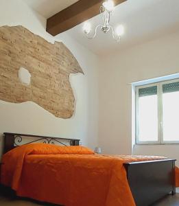 a bedroom with a bed and a brick wall at Sindaro house in Messina