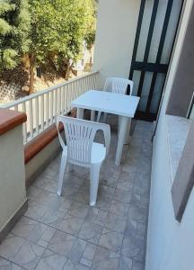 - Balcón con mesa blanca y 2 sillas blancas en Sindaro house en Messina