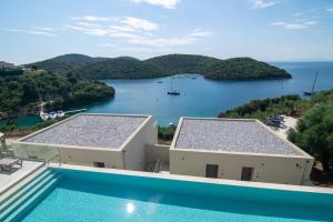 a swimming pool with a view of a body of water at Sivota Deamaris Luxury Boutique Hotel in Syvota