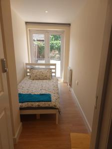 Habitación pequeña con cama y ventana en Vibrant Single Room only for one adult en Southall