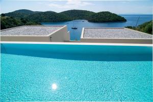 two images of a swimming pool with a view of the water at Sivota Deamaris Luxury Boutique Hotel in Syvota