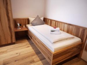 a wooden bed with two towels on top of it at DEVA Hotel Alpenglück in Weißbach +44 photos