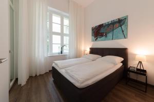 una camera da letto con un grande letto con lenzuola bianche di Lunas Appartements in der alten Schule Essen a Essen