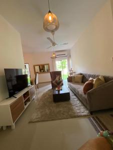 a living room with a couch and a flat screen tv at 3 Bedroom Apartment, Ariyana Resort in Athurugiriya