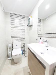 Un baño blanco con inodoro y lavabo. en Vista Mar, en Puerto del Rosario