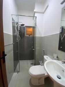 a bathroom with a shower and a toilet and a sink at 3 Bedroom Apartment, Ariyana Resort in Athurugiriya