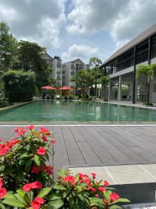 una piscina con fiori rossi di fronte a un edificio di 3 Bedroom Apartment, Ariyana Resort ad Athurugiriya
