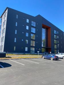 a black building with cars parked in a parking lot at Skyview apartment Kalajoki Hiekkasärkät in Kalajoki