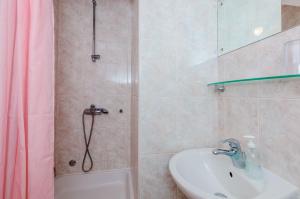 La salle de bains est pourvue d'une douche, d'un lavabo et d'une baignoire. dans l'établissement Small and friendly traditional home, à Zaton
