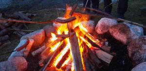 a campfire with rocks and people standing around it at Wathne Camping in Bjørheimsbygda
