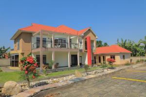 een groot huis met een oranje dak bij SILVER OAKS HOTEL Boma in Fort Portal