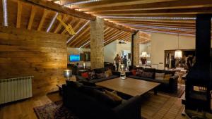 una sala de estar con sofás y techo de madera. en Lo Indiano, casa de turisme rural, en Prat de Comte