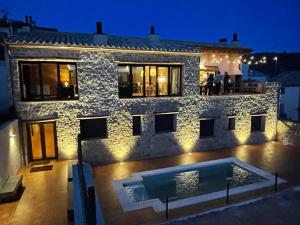 a house with a swimming pool in front of it at Lo Indiano, casa de turisme rural in Prat de Compte