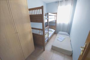a small room with two bunk beds and a door at Apto Gerard in L'Ampolla +13 photos