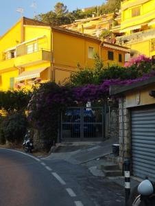 a yellow building with purple flowers on the side of a street at In panoramica da mechina in Porto Santo Stefano
