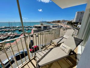a balcony with chairs and a view of a marina at Apto Panoramic in L'Ampolla