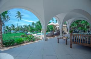 a pavilion with a bench and a pool at Mzima Beach Residences - Diani Beach in Diani Beach