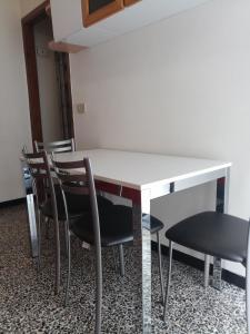 een witte tafel en stoelen in een kamer bij Interno2 in Diano Marina