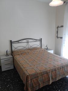 een slaapkamer met een bed met een geruite deken bij Interno2 in Diano Marina