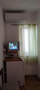 DVOKREVETNA SOBA SA KUPAONICOM في فوديس: غرفة مع تلفزيون على مكتب مع نافذة