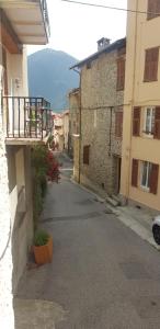 an alley with buildings and a balcony in a city at Studio cosy au coeur de Saint Martin Vésubie in Saint-Martin-Vésubie +3 photos