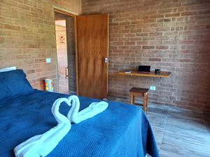 a room with a bed with two swans on it at Recanto da Pedra Chalé in São Bento do Sapucaí