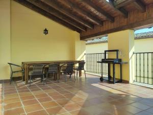 a patio with a table and chairs and a piano at Gure Etxea in Sesma