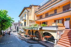 a street in an old town with tables and chairs at Prestige rooms in Sirmione