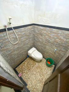 a bathroom with a toilet in a brick wall at Omah Tukangan Homestay in Yogyakarta