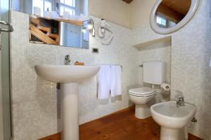 Cà 'd Calin Casa nel Borgo في سيرالونغا دو ألبا: حمام مع حوض ومرحاض ومرآة