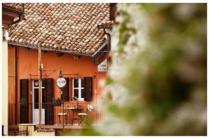 una casa de color naranja con un balcón delante en Cà 'd Calin Casa nel Borgo, en Serralunga d'Alba