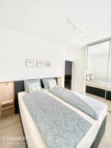 sypialnia z dużym łóżkiem i lustrem w obiekcie CASHMERE Premium Apartment w Siófoku