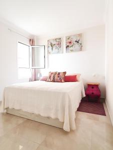 Un dormitorio blanco con una cama blanca y dos ventanas. en Vista Mar, en Puerto del Rosario