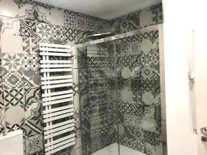 a bathroom with a shower with black and white tiles at Precioso apartamento en Bueu 50 metros de la playa in Bueu