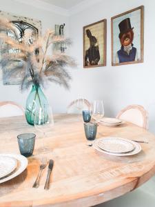 a wooden table with plates and a vase with a plant at Vista Mar in Puerto del Rosario